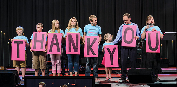 Matt and Katie Proctor and their six children, each wearing a “Cancer is bad, but God is good” T-shirt, thank worshippers in the opening-night NACC crowd for their prayers in the months that have followed Katie’s February cancer diagnosis.